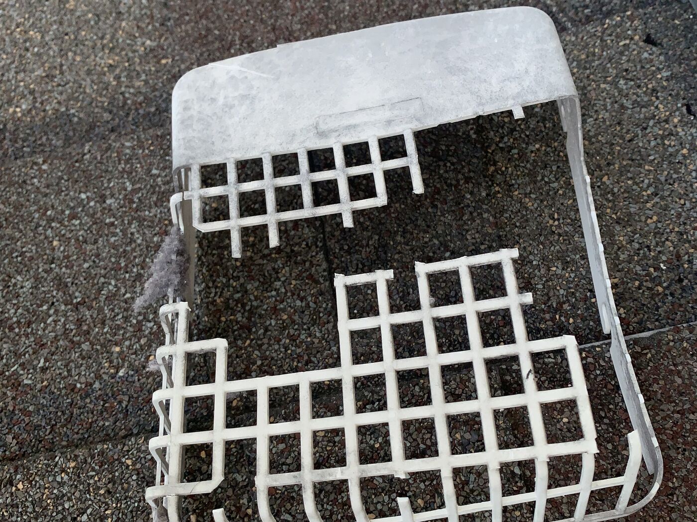 Broken exterior dryer vent cover removed from a roof termination