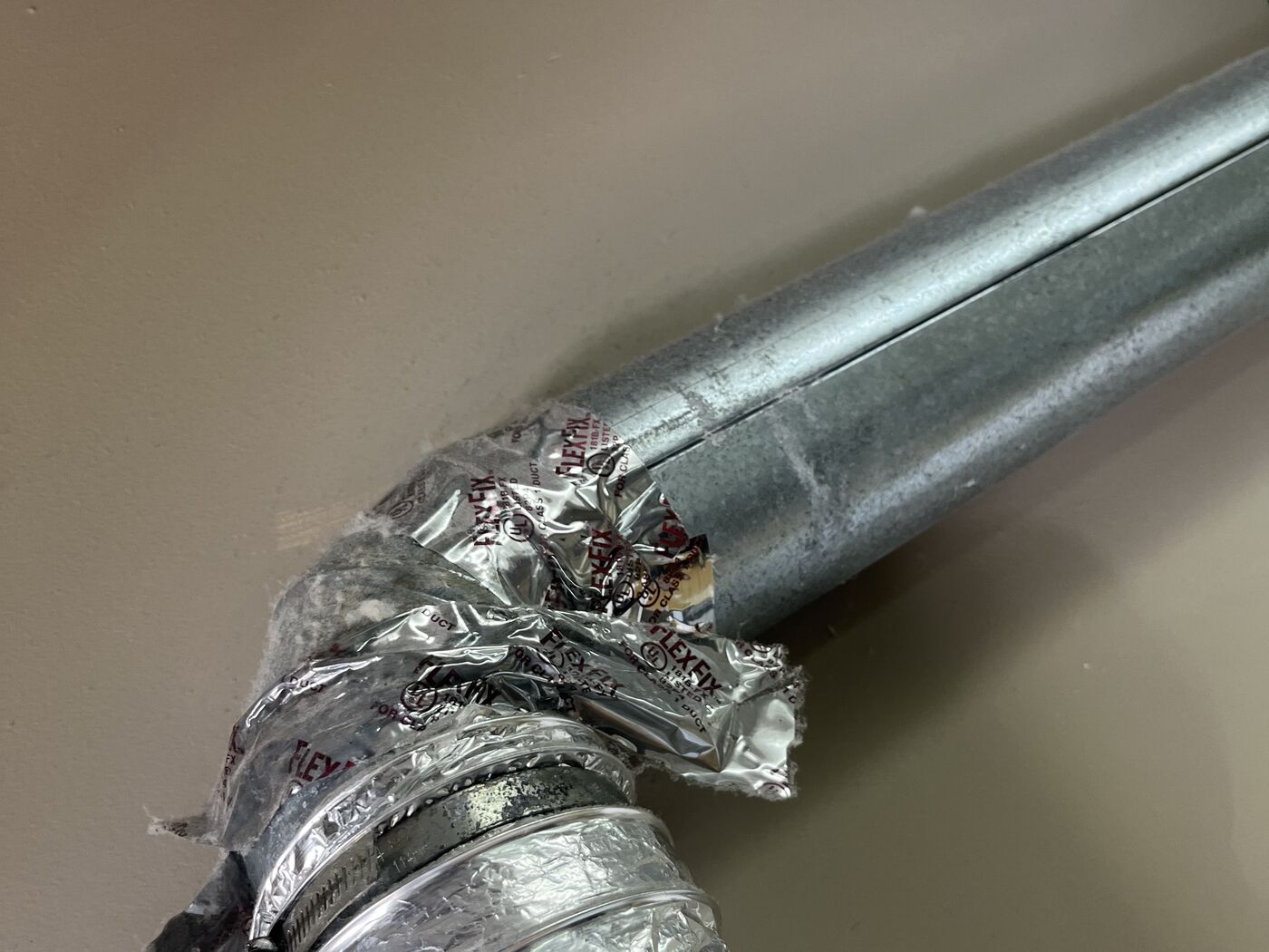 Damaged foil transition duct on a commercial dryer before replacement